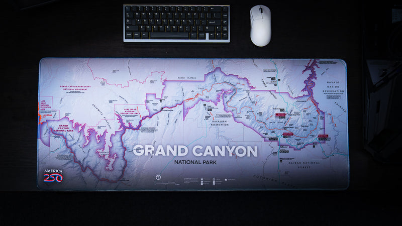 Overhead view of the Grand Canyon Purple deskmat featuring a detailed purple-themed topographic map of Grand Canyon National Park with a mechanical keyboard and mouse.