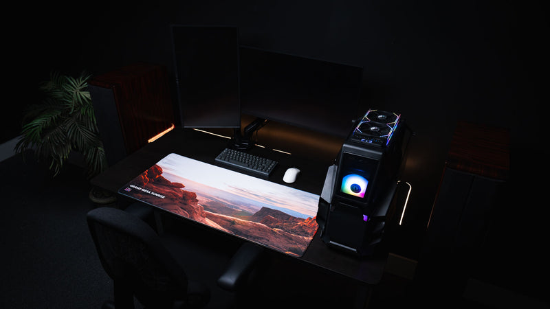 Grand Mesa Sunrise America 250 deskmat displayed in an RGB PC setup with Canyonlands sunrise artwork, red rock cliffs, keyboard, and mouse.