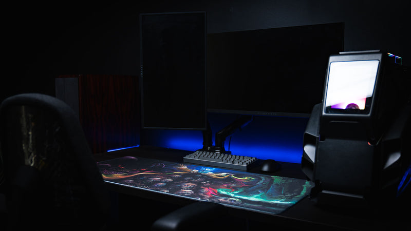 Front view of a dark PC workspace featuring the colorful Dominion of the Dark gaming desk mat