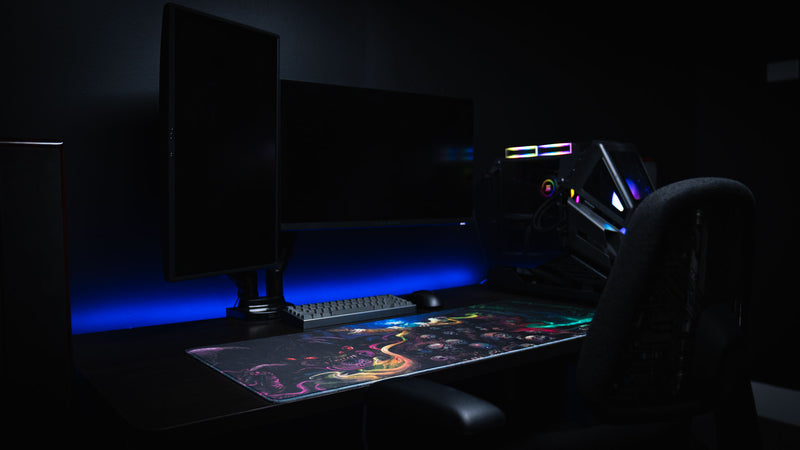 Side view of a blue-lit gaming station featuring the Dominion of the Dark desk mat