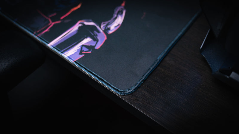 Close view of the stitched corner and character artwork on the Redemption on the Old Road desk mat