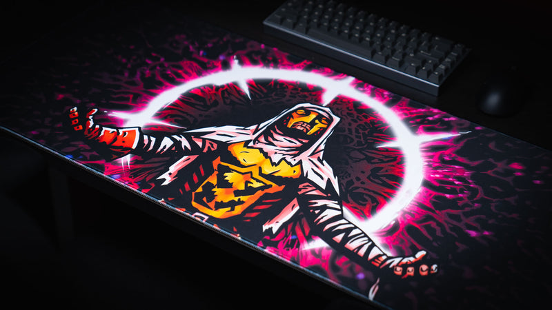Angled view of the Grim Kleeper Spare Them gaming desk mat beneath a compact keyboard