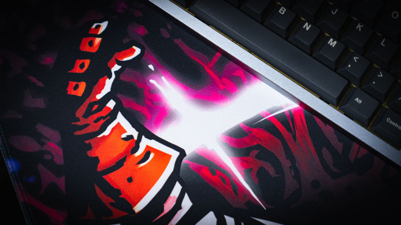 Close view of the crusader hand and glowing white-pink ring beside a keyboard on the Spare Them desk mat