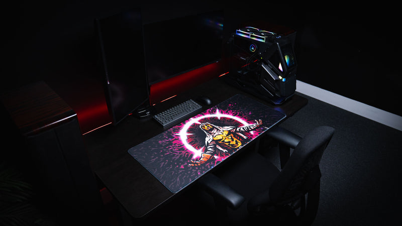 Side view of a dark PC workstation featuring the Grim Kleeper Spare Them gaming desk mat