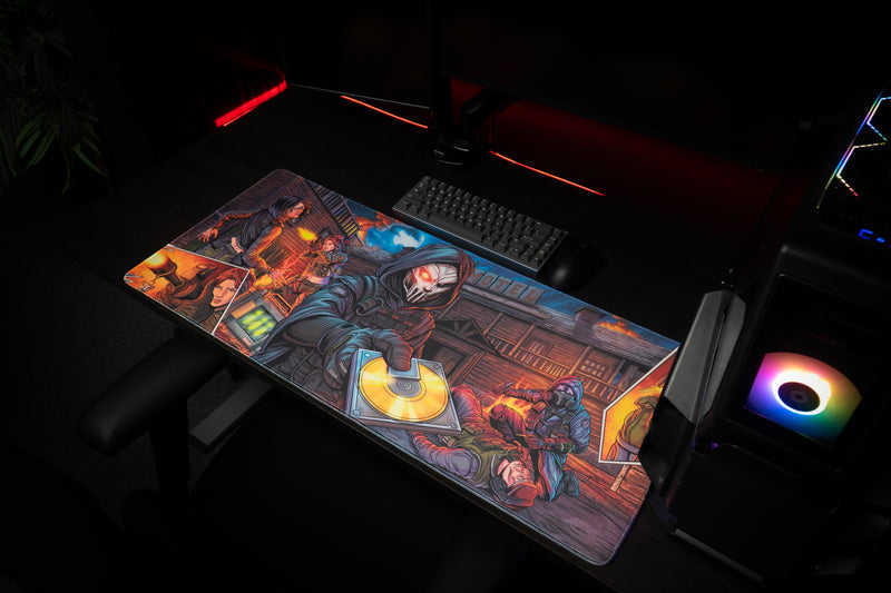 Overhead view from the right of the Head Hunters deskmat beside a keyboard and RGB-lit PC.