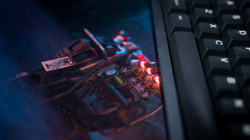 Close-up of a keyboard resting beside the generator artwork on Hens The Last Campfire gaming deskmat.