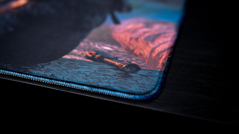 Close-up of the blue stitched corner and flashlight artwork on Hens The Last Campfire gaming deskmat.