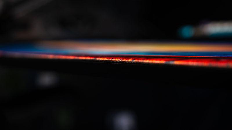 Ultra-low profile close-up of Posty's How Do You Fish deskmat highlighting the stitched edge, premium thickness, and vibrant printed artwork.