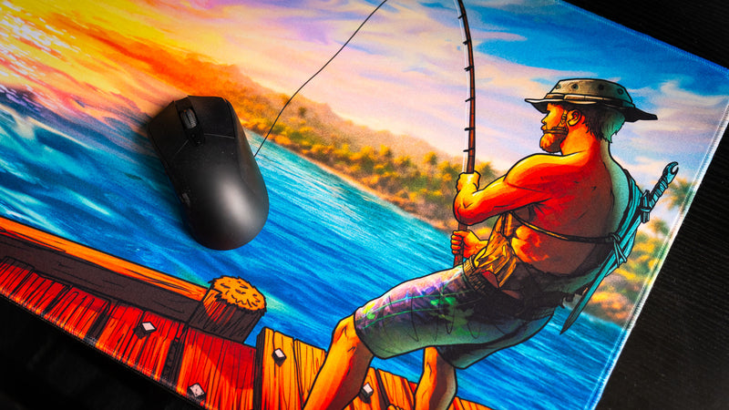 Close-up of Posty's How Do You Fish deskmat featuring the fisherman artwork beneath a gaming mouse, showcasing vibrant colors and detailed illustration.