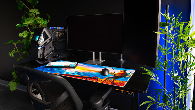 Angled view of Posty's How Do You Fish deskmat featuring a fisherman standing on a wooden dock overlooking a bright ocean sunset.