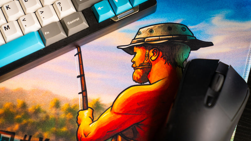 Close-up detail of the fisherman artwork on the How Do You F@#k Do You Fish deskmat by Posty, showcasing vibrant sunset lighting, illustrated character detail, and premium print quality.
