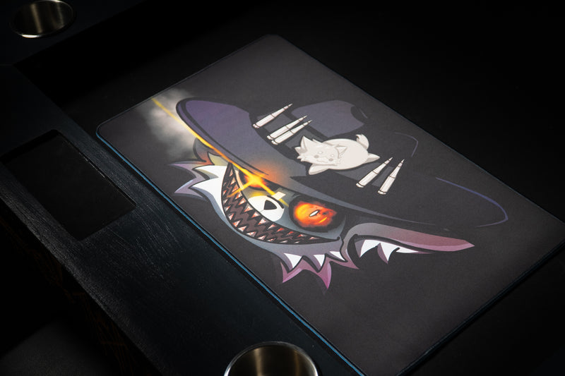 Iddqd Chonk Mat playmat on a card table beside a recessed tray and cup holders, viewed from the opposite corner.