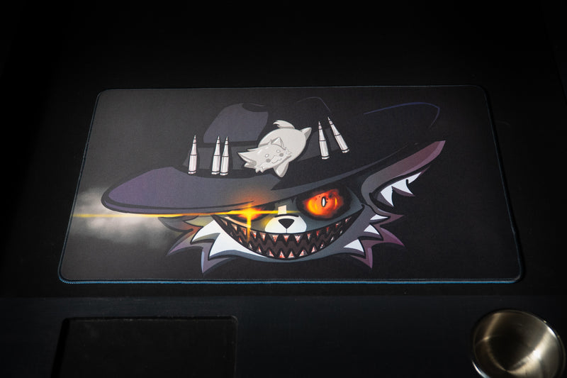 Top view of Iddqd's Chonk Mat playmat on a gaming table, displaying the full cowboy cat design against a smoky background.