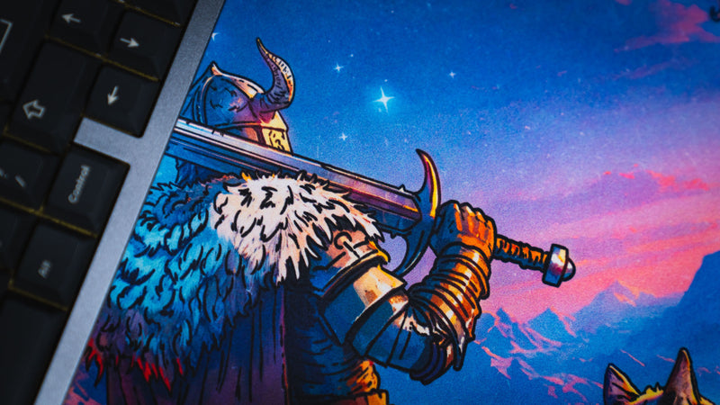 Close-up of the armored warrior holding a sword on the Jakk Frost Hold desk mat beside a keyboard