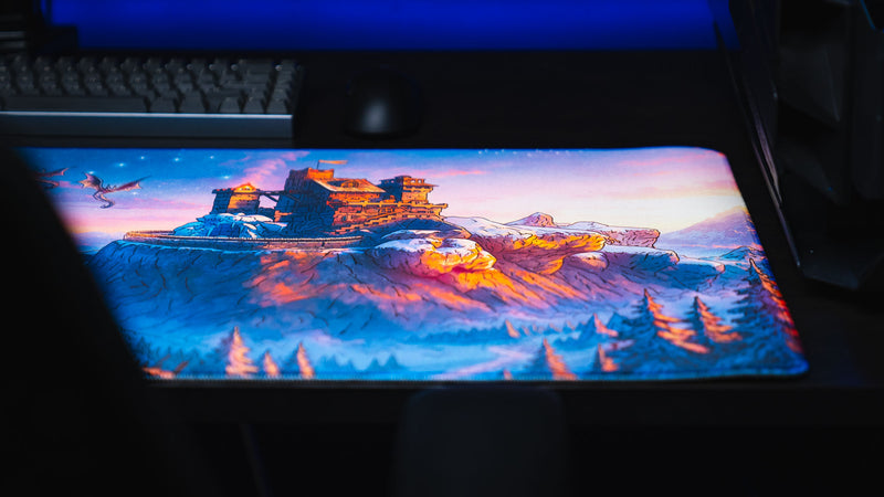 Front view of the snowy cliffside fortress section of the Jakk Frost Hold desk mat beneath a keyboard