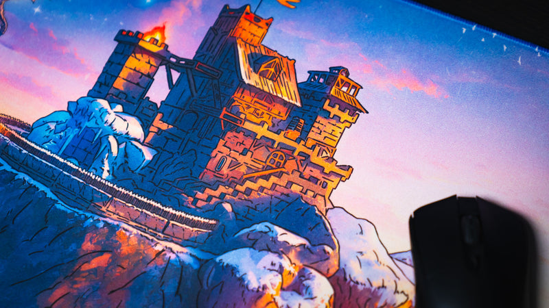 Mouse beside the illuminated snowy fortress artwork on the Jakk Frost Hold gaming desk mat