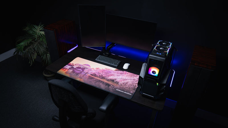 Wide-angle view of the America 250 Jefferson Memorial deskmat featuring the Jefferson Memorial and cherry blossoms on a premium gaming desk with a mechanical keyboard, gaming PC, and white gaming mouse.