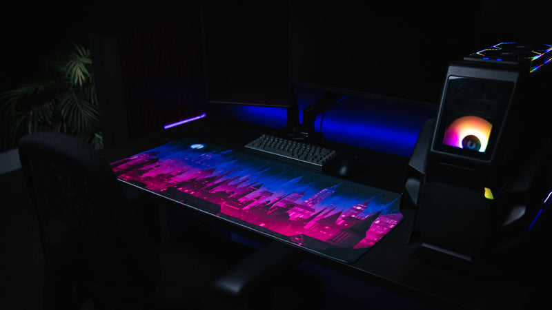 Chroma Kingdom deskmat displayed beside an RGB gaming PC and dual monitors