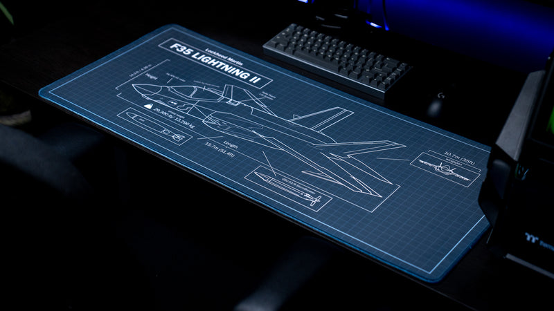Jimarkus F35 Schematic deskmat featuring a Lockheed Martin F-35 Lightning II blueprint displayed on a desktop with a mechanical keyboard and gaming mouse.