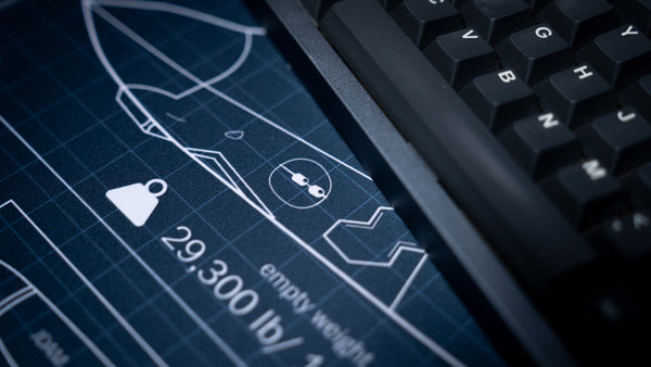 Close-up of the cockpit blueprint details on the Jimarkus F35 Schematic deskmat beside a mechanical keyboard, showcasing the Lockheed Martin F-35 Lightning II design.