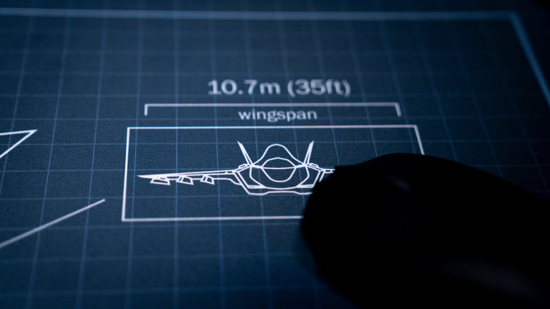 Close-up of the wingspan blueprint diagram on the Jimarkus F35 Schematic deskmat featuring the Lockheed Martin F-35 Lightning II with a gaming mouse in view.