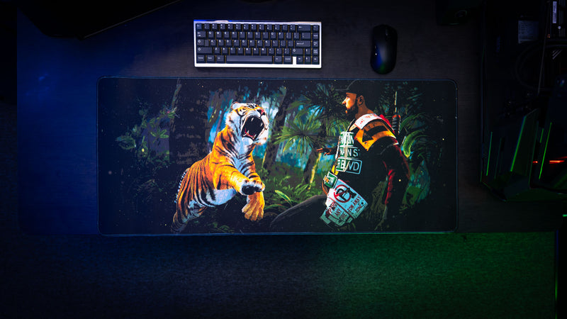 Overhead view of the official Rust Jungle Ambush deskmat featuring a survivor confronting a roaring tiger in a dense jungle environment.