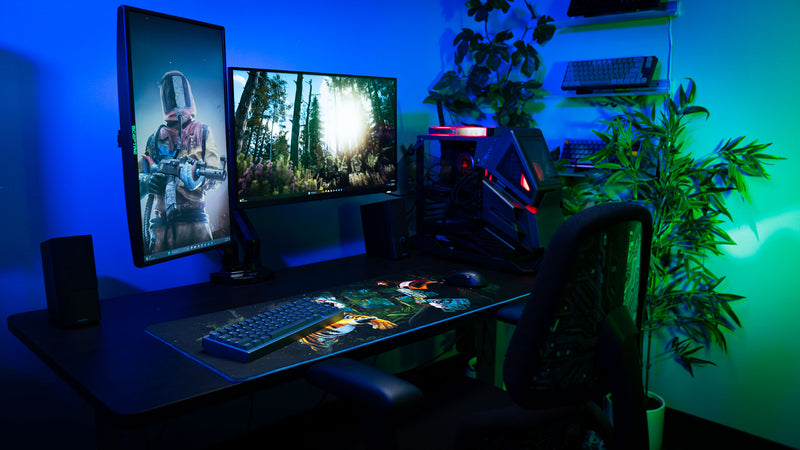 Premium gaming battlestation featuring the official Rust Jungle Ambush deskmat, dual monitors, custom PC, and jungle survival artwork.