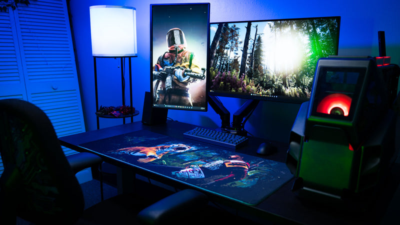Gaming setup featuring the official Rust Jungle Ambush deskmat with dual monitors, custom PC, and immersive jungle-themed artwork.