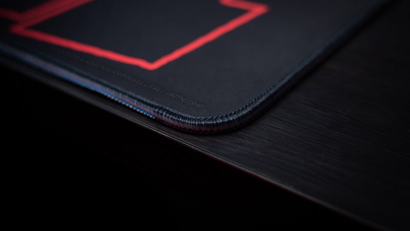 Close-up of the Kill la Kill “Kamui Clash” deskmat highlighting stitched edges, dark premium fabric, and glowing red geometric artwork