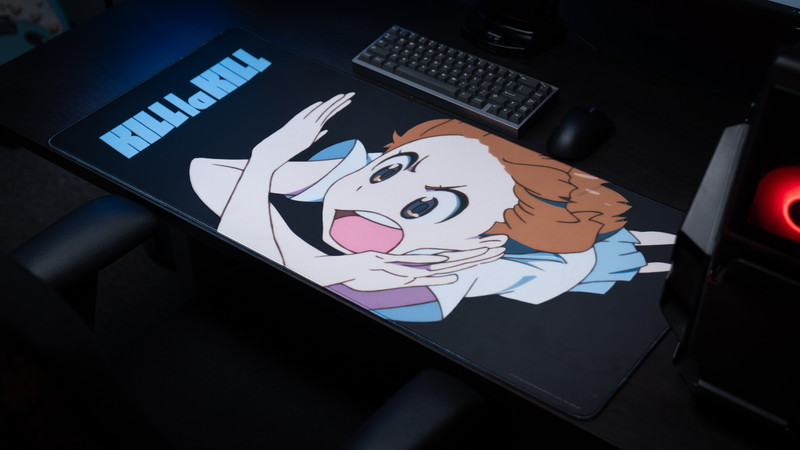 Anime battlestation setup featuring the Kill la Kill “Mako’s Fury” deskmat with expressive character artwork, mechanical keyboard, and gaming mouse.