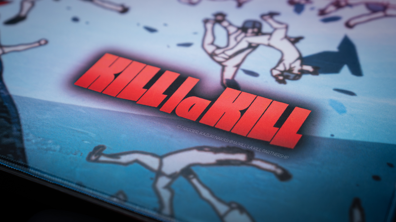 Close-up of the Kill la Kill “Ryuko’s Rampage” anime deskmat featuring bold red logo artwork and dynamic battle scene details.