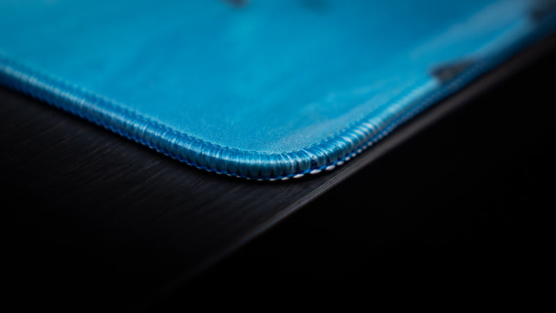 Close-up of the Kill la Kill “Ryuko’s Rampage” deskmat highlighting premium stitched edges and smooth blue fabric surface.