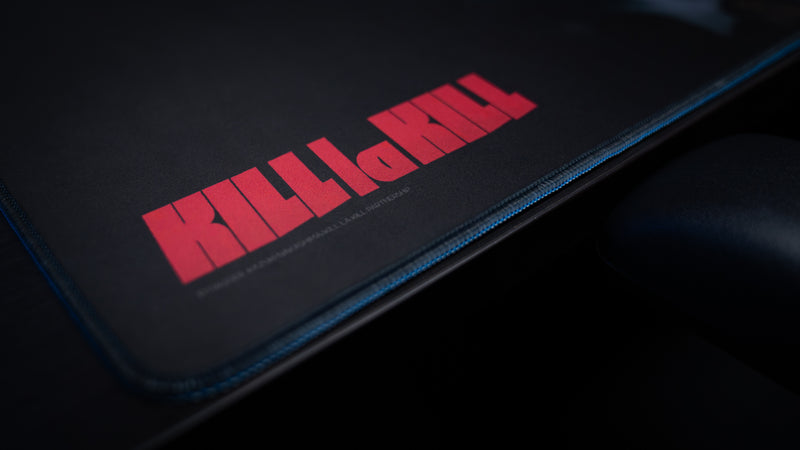 Close-up of the Kill la Kill “Scissorblade” anime deskmat featuring minimalist black design, red Kill la Kill logo, and stitched edges.