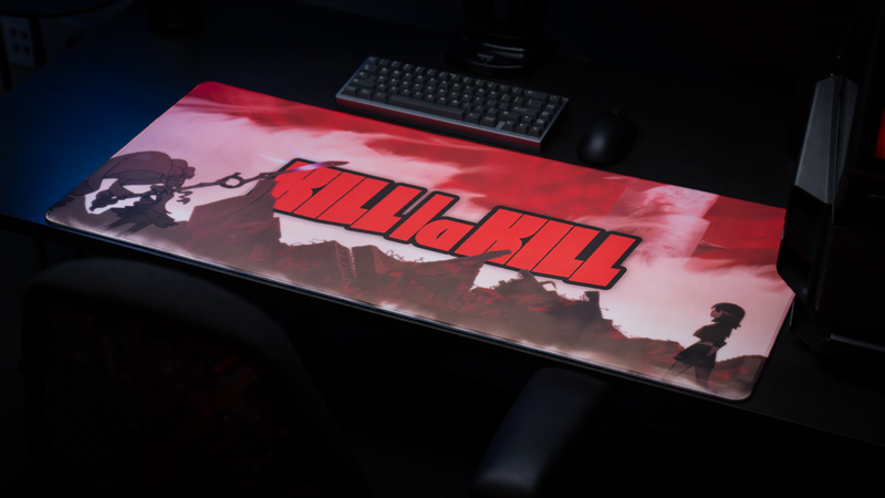 Anime gaming battlestation featuring the Kill la Kill “The First Duel” deskmat with bold red artwork, silhouetted characters, keyboard, and mouse setup
