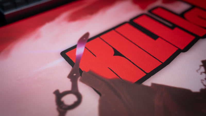 Close-up of the Kill la Kill “The First Duel” anime deskmat highlighting bold red logo artwork and detailed character silhouette illustration