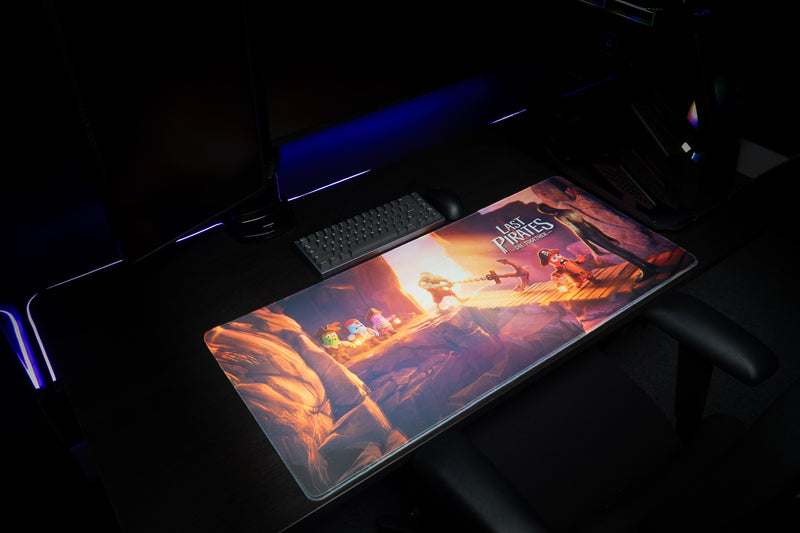 Angled view of the Bridge Escape desk mat in a gaming setup, showing the canyon and pirate bridge scene