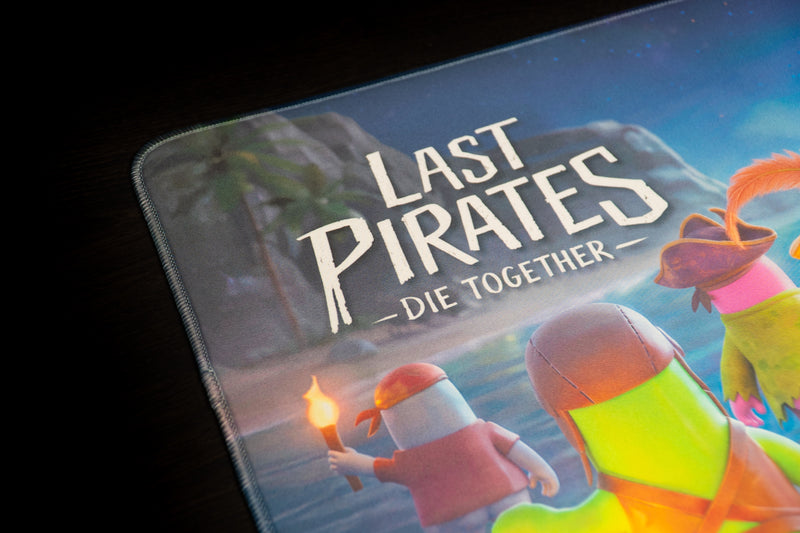 Close-up of the Last Pirates game logo and pirate characters on the Kraken Tide desk mat