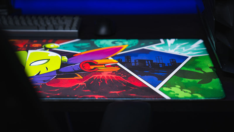 Angled view of the Lure of the Night gaming deskmat featuring the colorful moth character with volcanic, city, and post-apocalyptic Rust-inspired comic panels.