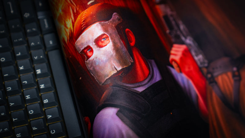 Close-up of the main scene Rust deskmat featuring the iconic metal mask character, showcasing the crisp artwork, vibrant colors, premium fabric texture, and detailed print quality beside a mechanical keyboard.