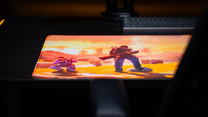 Angled gaming setup featuring the main scene Rust deskmat with the iconic rocket raider at the center of the artwork, highlighting the vivid sunset colors, premium print quality, stitched edges, and oversized gaming mouse pad surface.