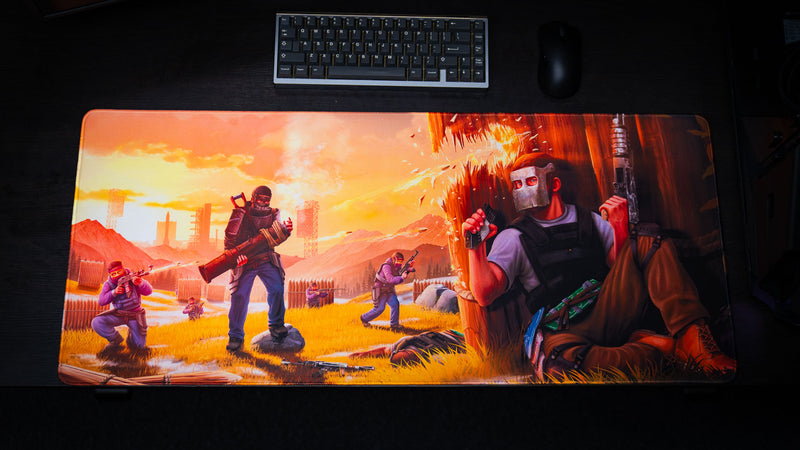 Top-down view of the main scene Rust deskmat featuring an intense firefight with players taking cover behind a wooden wall, explosions, rockets, and a vivid sunset across an extended premium gaming mouse pad.