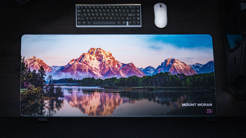 Top-down view of the Mount Moran deskmat featuring a panoramic Grand Teton National Park landscape reflected in Jackson Lake with premium stitched edges and vivid HD photography.
