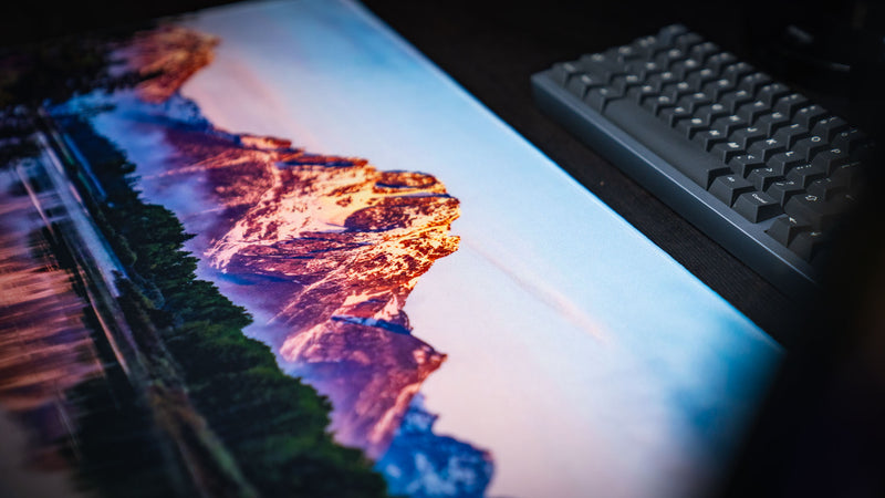Close-up of the Mount Moran deskmat showcasing the snow-capped Grand Teton peak, vibrant sunrise colors, premium HD photography, and smooth gaming surface.