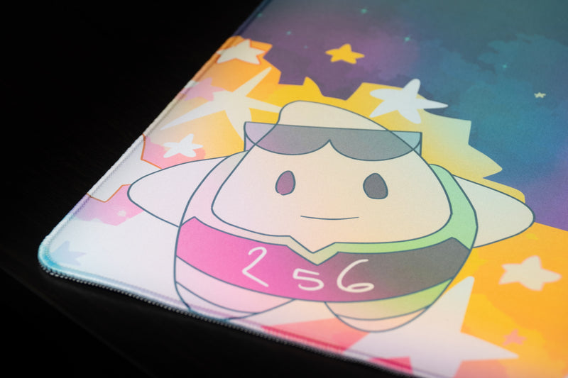 Close-up of the sunglasses-wearing 256 mascot and colorful stars on MVPCHAN's MVP Galaxy desk mat.