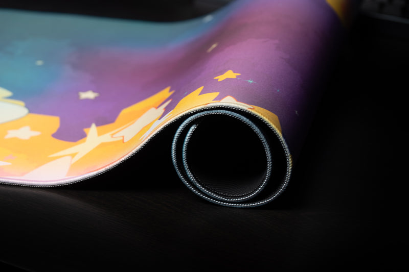 Close-up of the rolled, stitched edge of the MVP Galaxy desk mat with its galaxy print visible.