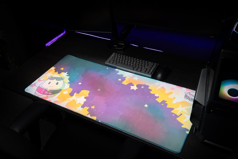 Wide gaming setup with the MVPCHAN MVP Galaxy desk mat, keyboard, and purple-lit PC.