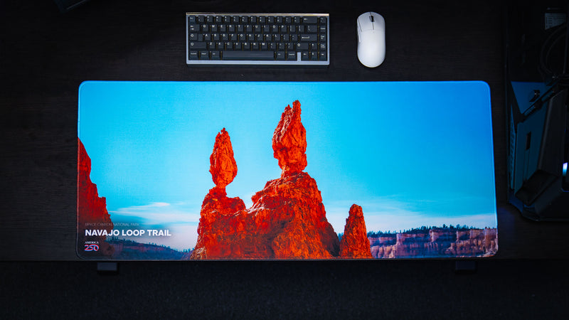 Top-down view of the Navajo Loop Trail deskmat featuring Bryce Canyon National Park's iconic Thor's Hammer hoodoo, premium stitched edges, and vibrant HD photography.