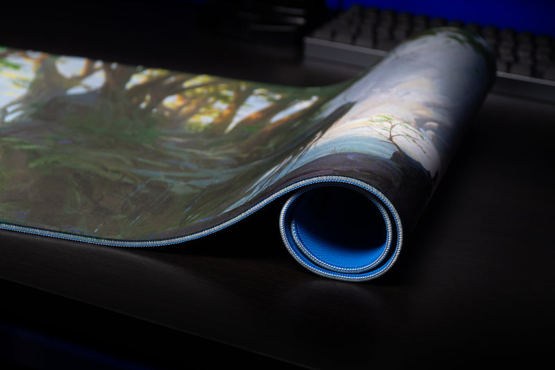 Close-up of the rolled Lake of Laugg deskmat showing the blue base and stitched edge
