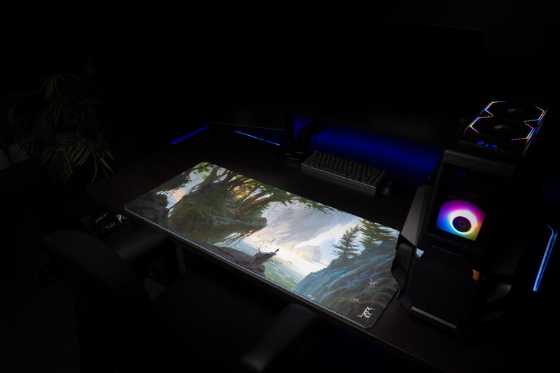 Lake of Laugg deskmat in an angled PC gaming setup with forest and lake artwork across the desk