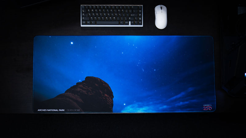 Top-down view of the Nightsky Death Bowl deskmat featuring the iconic Arches National Park rock formation beneath a star-filled night sky in the America 250 collection.